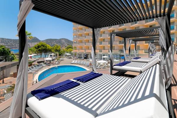 Außenbereich des H10 Blue Mar Boutique Hotels mit Sonnenliegen, Pool und Bergpanorama