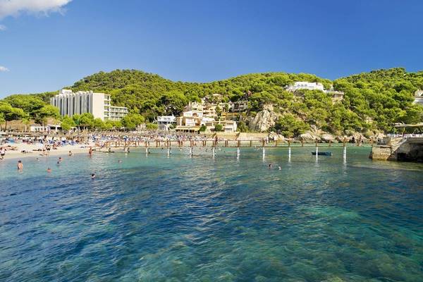 Strand mit vielen Gästen und dem H10 Blue Mar Boutique Hotel im Hintergrund
