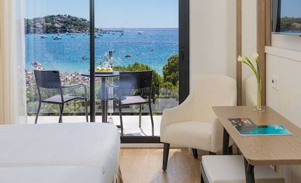 Doppelzimmer im H10 Casa del Mar Hotel mit Meerblick, inklusive zwei Betten, Tisch mit Stühlen und Fernseher.