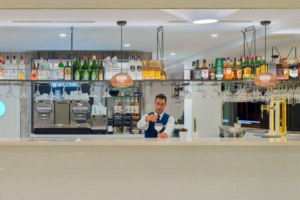 Die Bar Theta im H10 Casa del Mar Hotel mit gut gekleideten Barkeepern und einer Auswahl an Getränken.