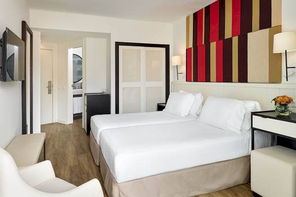 Doppelzimmer im H10 Casa del Mar Hotel mit zwei Betten, moderner Einrichtung und farbenfrohem Wanddesign.