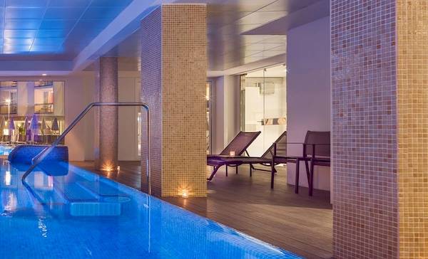 Innenpool des H10 Casa del Mar Hotels mit blau beleuchtetem Wasser und gefliesten Wänden.