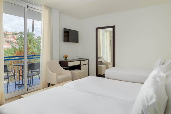 Doppelzimmer im H10 Casa del Mar Hotel mit Balkon, zwei Betten, Schreibtisch und Aussicht auf die Stadt.