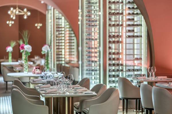 Inneneinrichtung des FIVE Palm Jumeirah Hotels mit runden Tischen, Stühlen und Weinregalen.