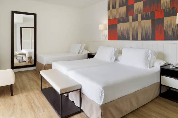 Doppelzimmer im H10 Casa del Mar Hotel mit zwei Betten, weißem Dekor und moderner Wandgestaltung.