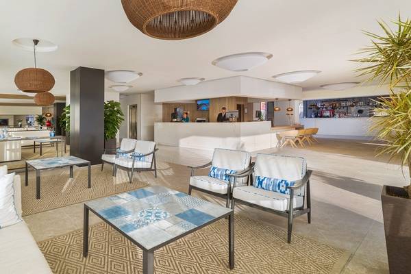 Lobby des H10 Casa del Mar Hotels mit modernen Möbeln, Sitzbereichen und einer Bar.