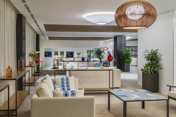 Innenansicht der Lobby des H10 Casa del Mar Hotels mit Sofas, Tischen und Pflanzen.