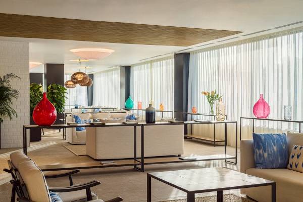 Lobby des H10 Casa del Mar Hotels mit Sofas, Tischen und farbigen Vasen.