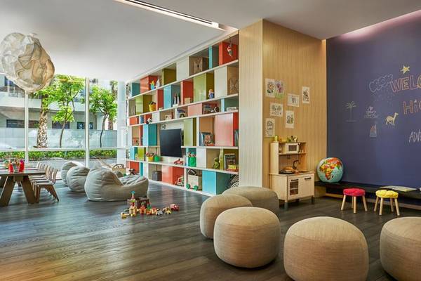 Kinderzimmer im FIVE Palm Jumeirah mit bunten Regalen, Spielsachen, Sofas und einer Wand mit Zeichnungen.