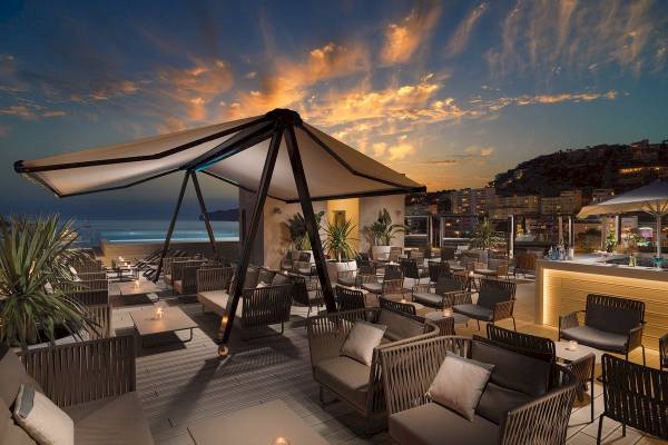 Dachterrasse des H10 Casa del Mar Hotels mit Loungemöbeln, Tischen und Blick auf die Stadt