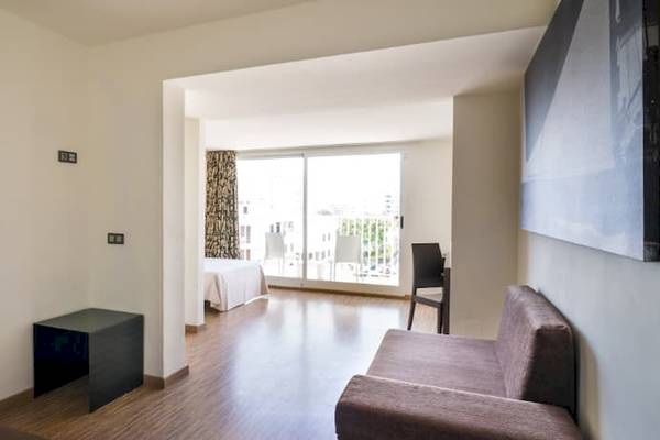 Innenansicht des Nautic Hotel & Spa Zimmers mit Couch, Tisch und Blick auf das Bett