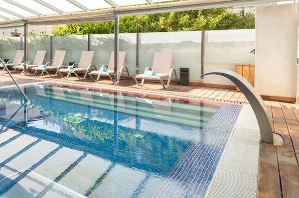 Poolbereich im Nautic Hotel & Spa mit Loungestühlen und Glasdach