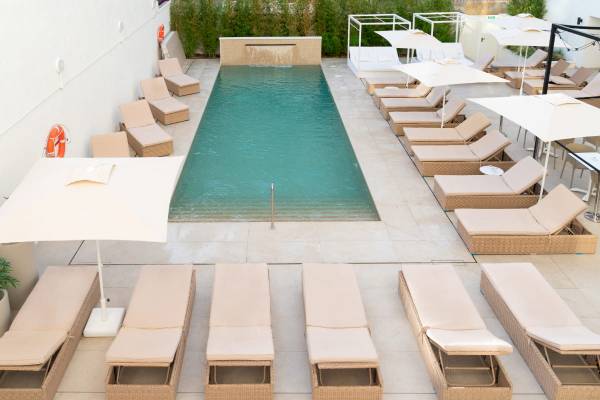 Pool-Loungebereich mit Sonnenschirmen und Rettungsschwimmer-Station im Nautic Hotel & Spa