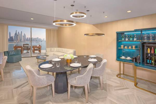 Innenbereich des FIVE Palm Jumeirah Hotels mit elegantem Esstisch und Blick auf die Stadt.