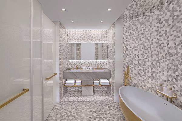 Das Badezimmer im FIVE Palm Jumeirah Hotel mit geometrischen Kacheln und einer Badewanne.