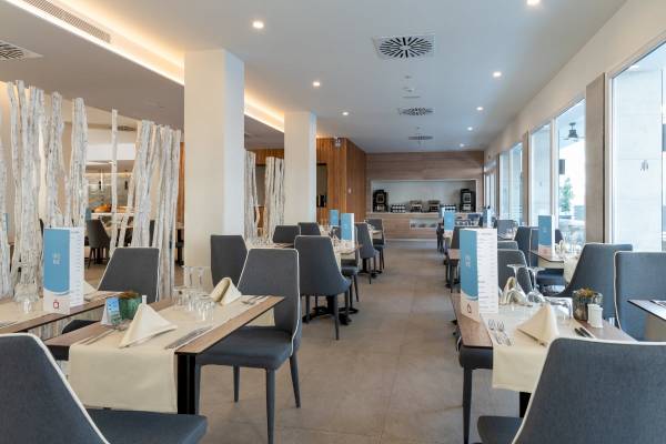 Innenansicht des Restaurants des Nautic Hotel & Spa mit gedeckten Tischen und Stühlen.