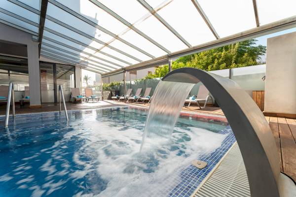 Ein Pool mit Wasserfall im Freien im Nautic Hotel & Spa.
