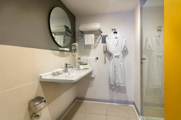 Badezimmer im Monachus Family Resort Sorgun mit Waschbecken, Spiegel und Bademantel