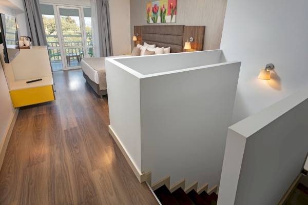 Ein modernes Hotelzimmer mit einem Bett, das an eine Wand mit einer Treppe angrenzt.