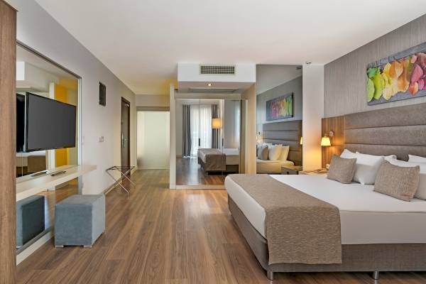 Ein modernes Hotelzimmer im Monachus Family Resort Sorgun mit Holzboden und Fernseher.
