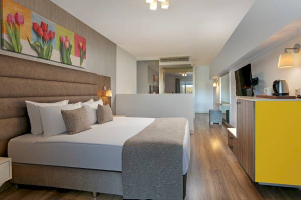 Schlafzimmer im Monachus Family Resort Sorgun mit Doppelbett, Fernseher und Deko