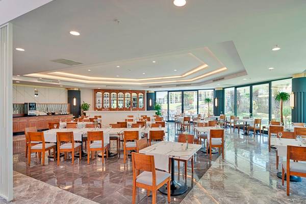 Innenansicht des Restaurants im Monachus Family Resort Sorgun mit vielen Tischen und Stühlen.