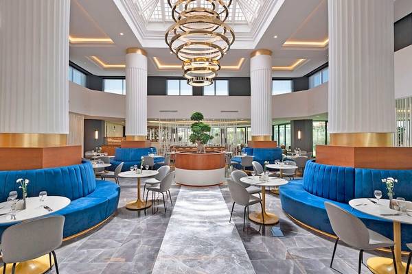 Ein elegantes Restaurant im Monachus Family Resort Sorgun mit blauen Sitzbänken und goldenen Tischen.
