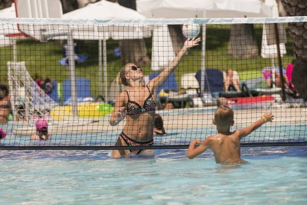 Eine Frau und ein Junge spielen Volleyball im Pool des Monachus Family Resort Sorgun.