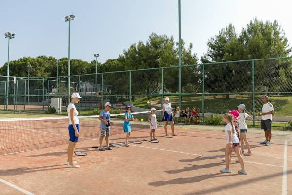 Tennisstunde auf dem Tennisplatz des Monachus Family Resort Sorgun mit Kindern und Trainern.