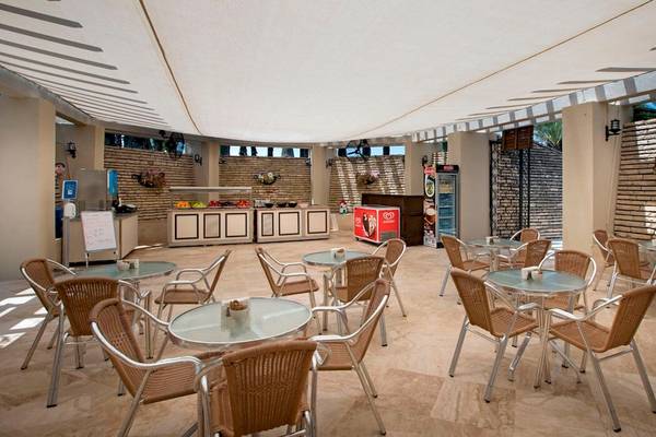 Innenbereich des Restaurants im Monachus Family Resort Sorgun mit Tischen und Stühlen unter einem Sonnendach.