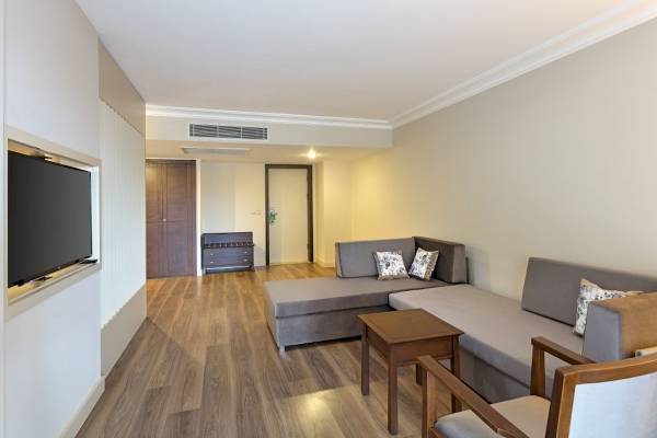 Innenraum des Seven Seas Hotel Life mit Wohnzimmer, Sofa, Fernseher und Holzboden.
