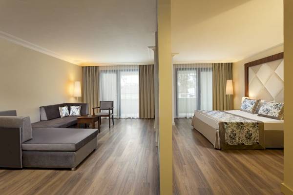 Innenansicht eines Schlafzimmers im Seven Seas Hotel Life mit Doppelbett, Sofa und Fenstern.