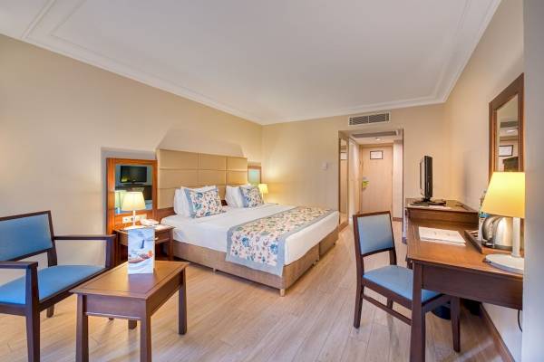 Schlafzimmer im Seven Seas Hotel Life mit einem Doppelbett, zwei Nachttischen, einem Schreibtisch und Stühlen.