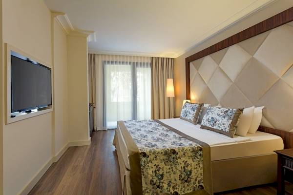 Doppelzimmerbett im Seven Seas Hotel Life mit Fernseher an der Wand und Fenstern.