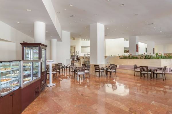 Innenbereich des Seven Seas Hotel Life mit geräumigen Sitzbereichen und einer Kuchentheke.
