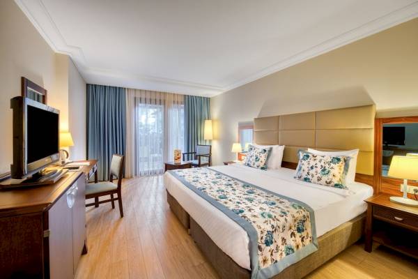 Schlafzimmer im Seven Seas Hotel Life mit Doppelbett, Fernseher, Schreibtisch und Stühlen.