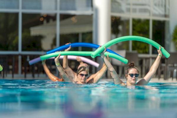 Gäste im Seven Seas Hotel Life schwimmen im Pool und nutzen Hula-Hoops.
