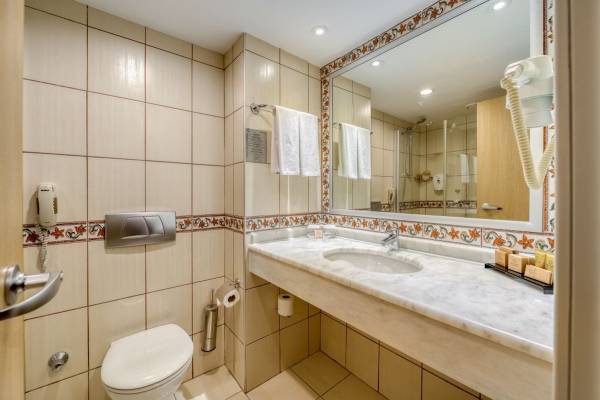 Badezimmer im Seven Seas Hotel Life mit Waschbecken, Spiegel und Toilette
