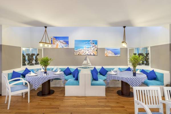 Innenbereich des Seven Seas Hotel Life mit zwei Tisch-Sets, blauen Kissen und Deko.