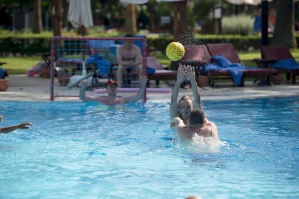 Mehrere Maenner spielen Wasserball im Schwimmbad des Seven Seas Hotel Life.