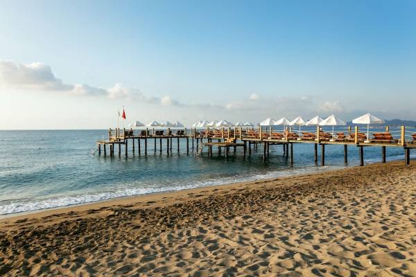 Pier am Strand mit Sonnenliegen und Sonnenschirmen vom Seven Seas Hotel Life