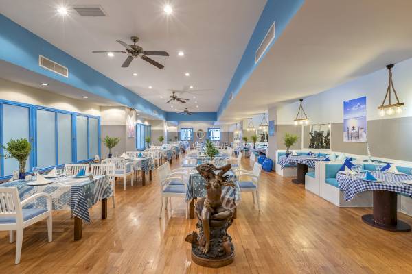Innenbereich des Seven Seas Hotel Life mit vielen Tischen und Stühlen, dekoriert mit Tischdecken und Skulpturen.