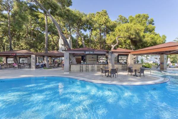 Pool-Bar-Bereich des Seven Seas Hotel Life mit blauem Wasser, Tischen und Stühlen unter Pavillons.