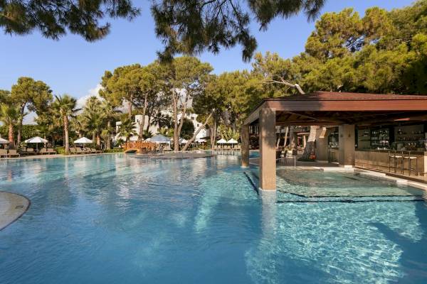 Außenpoolbereich des Seven Seas Hotel Life mit Loungeliegen und Schirmen.