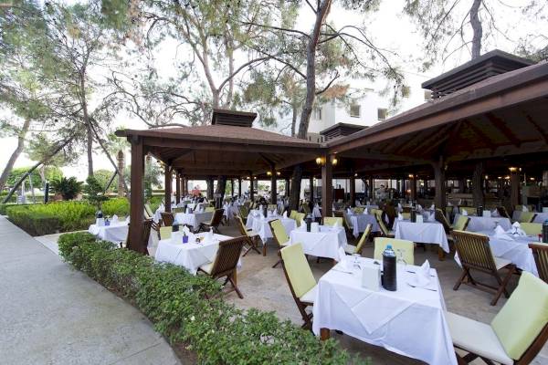 Außenbereich des Seven Seas Hotel Life Restaurants mit gedeckten Tischen und grünen Stühlen.