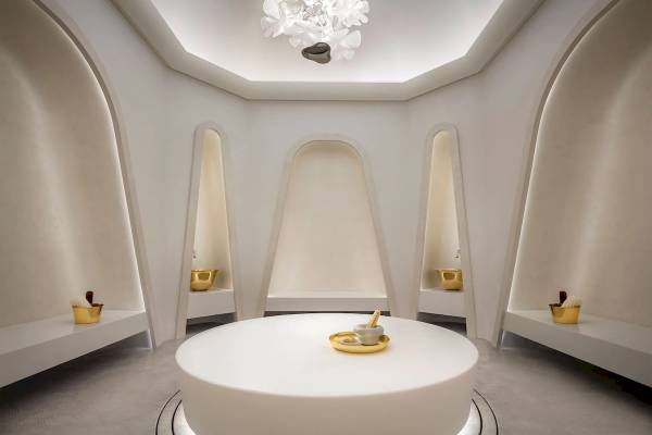 Wellnessbereich im Atlantis The Royal Hotel mit einem zentralen runden Tisch und goldenen Schalen.