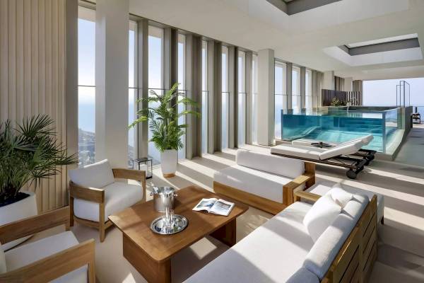 Wohnzimmer im Atlantis The Royal mit großer Fensterfront, Pool und Blick auf den Ozean.