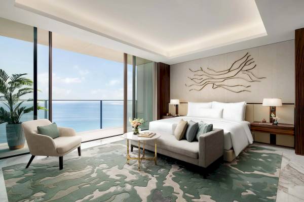 Eine Luxussuite im Atlantis The Royal mit Blick auf das Meer von einer großen Glaswand aus.