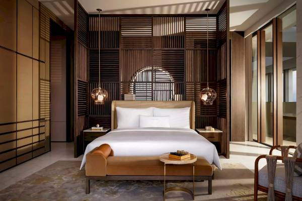Innenansicht des Schlafzimmers im Atlantis The Royal mit Doppelbett, Nachttischen und hängenden Lampen.