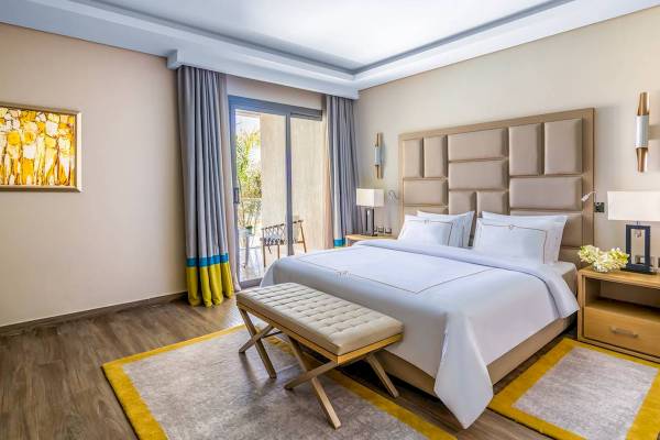 Hotelzimmer im Rixos Premium Magawish Suites & Villas mit einem Bett und einem Balkon.